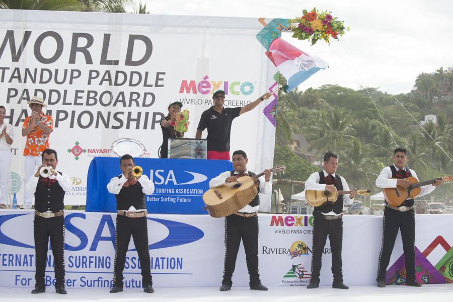 Aida Ramos and Fernando Stalla from Team Mexico pour sand into a glass container during the Sands of the World Ceremony to symbolize the peaceful gathering of Surfing and SUP nations. Photo: ISA/Brian Bielmann